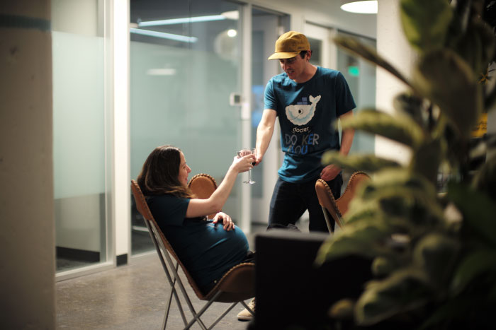 Des employés de Docker, avec un t-shirt Docker Cloud, trinquent lors du 3ème anniversaire de la boîte.  - by Laurel Duermael 